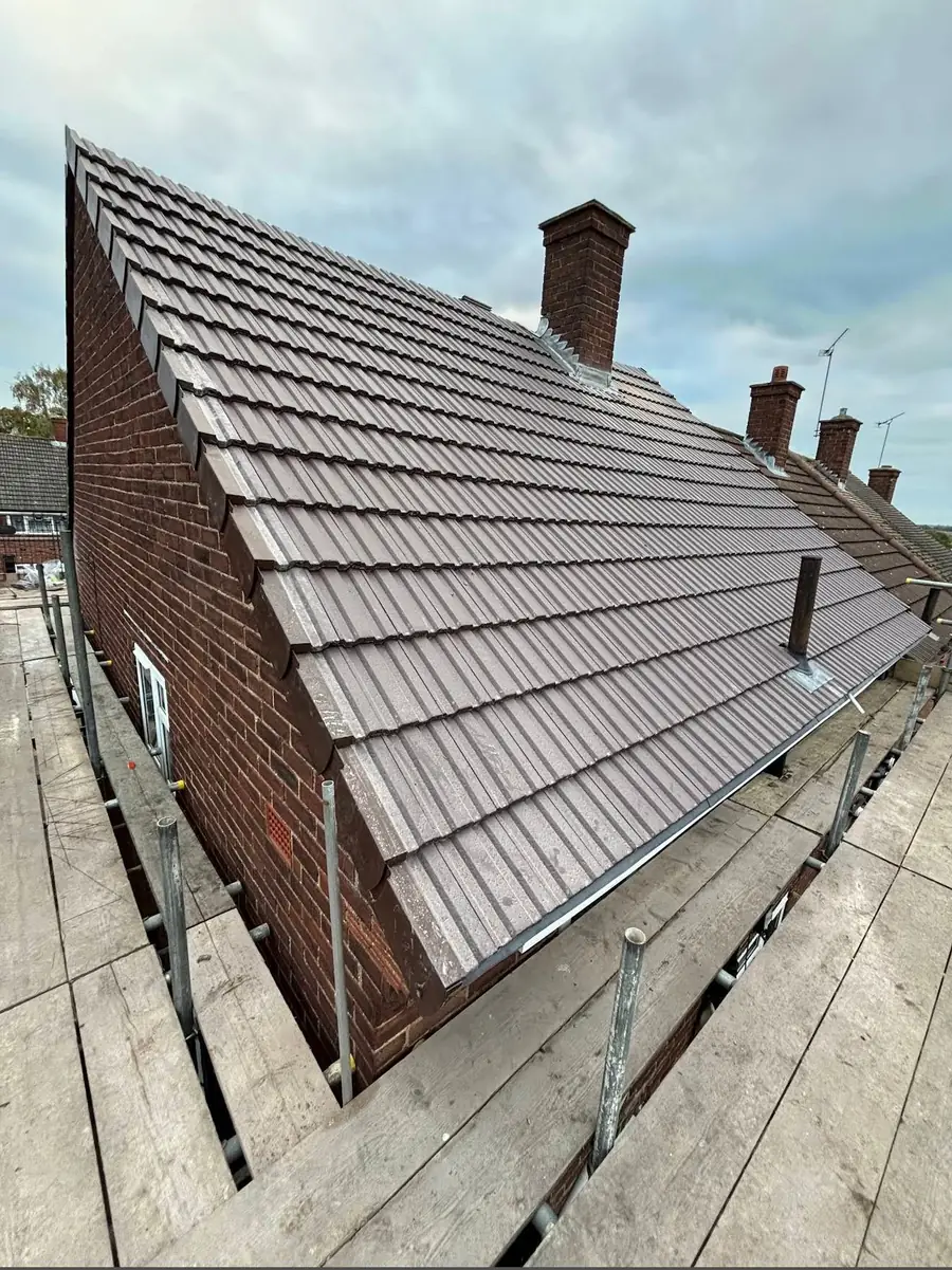 Brown tiled hipped roof completed on scaffold